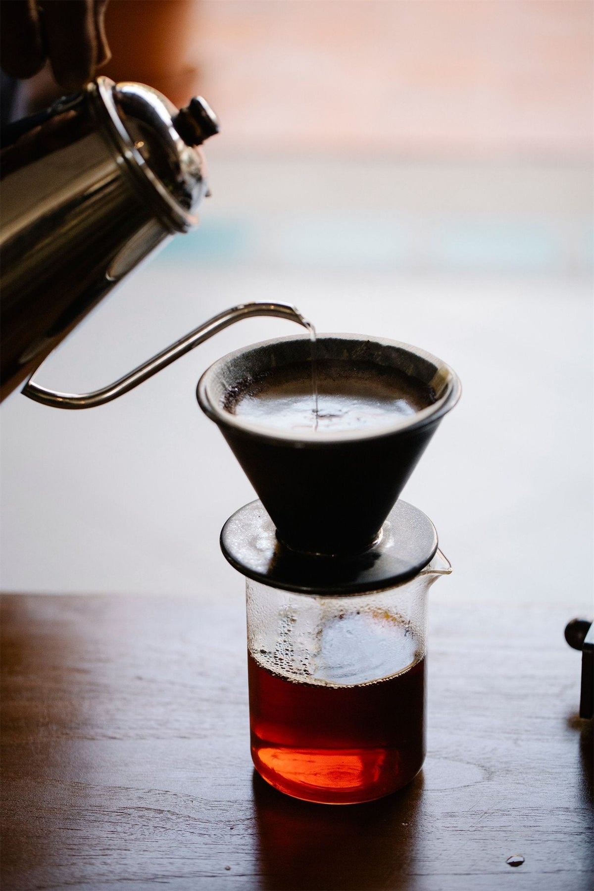 Kaffe som bryggs för hand genom en svart dripper